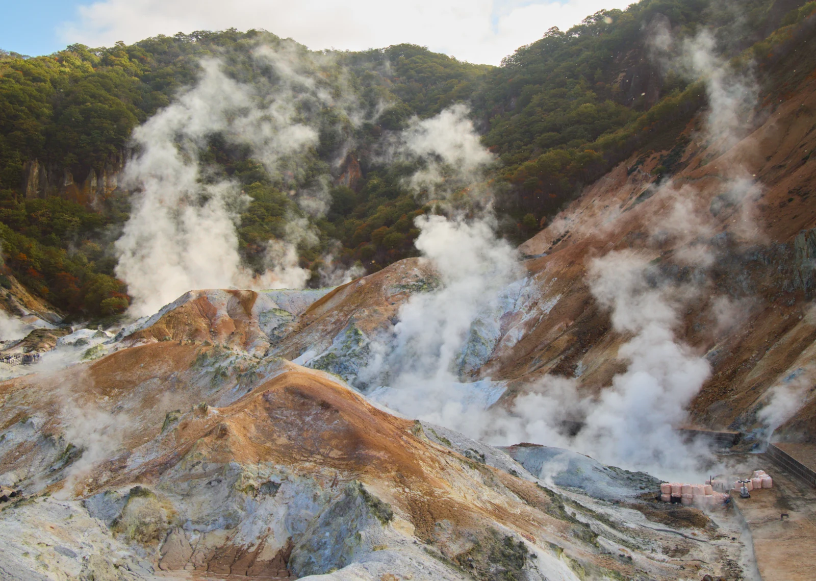 New Chitose Airport to Noboribetsu 2026: Bus vs Train Steam rising above mineral-stained ground at Jigokudani in Noboribetsu Onsen