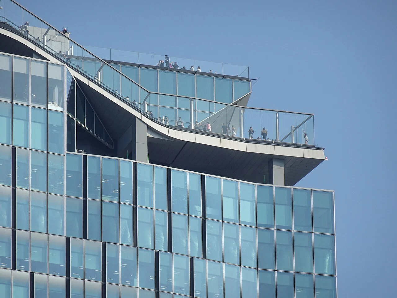 SHIBUYA SKY Guide 2026: Tickets, Sunset and Rooftop Rules Glass barriers, an outdoor escalator and rooftop viewing areas at SHIBUYA SKY, seen from Miyashita Park